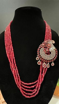 This necklace is a statement piece with a beautiful red/magenta shade and comes with a matching pair of earrings. The length can be adjusted accordingly. Pink Ruby Necklace For Party, Red Bridal Necklace For Party, Red Costume Jewelry Necklaces For Party, Temple Jewelry Style Pendant Necklaces For Party, Unique Red Necklace With Large Pendant, Formal Pink Necklaces With Matching Earrings, Red Long Necklace For Party, Formal Ruby Pendant Necklace, Elegant Red Beaded Jewelry