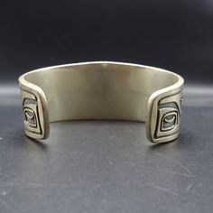 "VINTAGE KABANA BRACELET DESCRIPTION: This handsome bracelet is a vintage piece from Kabana, makers of fine southwestern jewelry since 1975. Images from the Pacific Northwest grace this heavy gauge sterling silver cuff. This bracelet will be a treasured addition to your collection of fine vintage Southwestern jewelry. MEASUREMENTS: Interior of the cuff measures 5 3/4\" with an additional 1 3/8\" non-adjustable gap. Total circumference: 7 1/8\" Measures 2 1/2\" straight across the widest part of Bohemian Engraved Jewelry For Collectors, Unique Etched Bangle Jewelry, Unique Adjustable Bracelets With Antique Finish, Unique Adjustable Bracelet With Antique Finish, Adjustable Bracelet With Antique Finish, Artisan Antique Silver Collectible Jewelry, Adjustable Antique Finish Jewelry Bracelet, Antique Handmade Adjustable Sterling Silver Bracelet, Handmade Adjustable Antique Bracelets