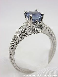 an antique style engagement ring with a blue stone in the center