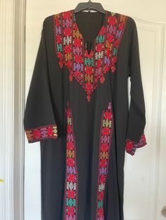 This is a Vintage Style Egyptian Arabic Bedouin Galabeya Abaya Kafatan Dress Hand Embroidered with Colorful Gorgeous Canvas all over it   Look at the Stunning Bedouin Tribal WorkLovely Handmade and crafted of Siwa Egypt. This Abaya dress is in never worn new condition.    Also i'm listing it's Matching Face Veil with Coins and scarf,  if you would like to take a look!   Its length : 54.5" -Around Hip : 27 inches, Bust 24.5 inches, Sleeves 23 inchesapproximately I believe it can fit size L : XL      Amazing it's a piece of Artyou will be impressed by it's Stunning colorful stitches and Bedouin Style.   Very nice Ethnic Bedouin Egyptian costume!     Please check the photos for more detailsBeautiful Handmade colorful Stitches.   Please, feel free to ask any questions before purchasing. ALL IT Traditional Black Maxi Length Thobe, Bohemian Black Abaya With Dabka Detailing, Traditional Multicolor Long Sleeve Maxi Dress, Black Kaftan With Traditional Patterns For Eid, Multicolor Long Sleeve Dress For Eid, Bohemian Black Thobe For Eid, Multicolor Traditional Maxi Dress For Eid, Multicolor Maxi Dress With Traditional Patterns For Eid, Festive Black Kaftan With Traditional Patterns