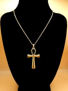 Discover the timeless elegance of our Ankh Pendant Necklace, a stunning piece of jewelry that transcends style boundaries. Expertly crafted with an 18k gold plating, this unisex necklace embodies the rich heritage of Ancient Egypt, featuring the iconic Ankh - the Key of Life. Made from hypoallergenic, tarnish-free 304 stainless steel, this necklace ensures comfort and longevity for even the most sensitive skin. The gold finish provides a luxurious touch, while its waterproof design guarantees du Luxury Yellow Gold Ankh Necklace, Classic Jewelry With Large Pendant As A Gift, Spiritual Ankh Pendant Jewelry, Spiritual Ankh Necklace In Yellow Gold, Spiritual Ankh Jewelry With Large Pendant, Yellow Gold Ankh Necklace, Gold Ankh Amulet Jewelry, Spiritual Gold Long Necklace, Amulet Style Ankh Necklace In Brass