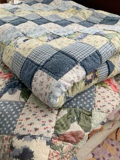 a quilted bed with blue and white flowers on it