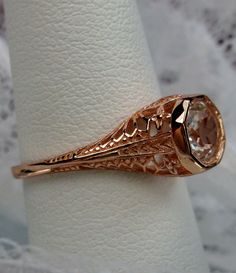 Natural White Topaz Ring Dandelion Design#205 Custom This is a stunning Edwardian wedding reproduction gemstone filigree ring. The approximate 1ct natural white topaz gemstone is 6mm in diameter. This lovely ring is 10K Rose Gold is marked 10K on the inner shank. Notice the beautiful craftsmanship of the rose gold filigree setting. This is an ornate and detailed ring. This is a lovely rendition of an Antique filigree wedding ring, and it is ready to wear. A ring gift box is included and all ring Rose Gold Filigree Wedding Jewelry, Rose Gold Filigree Jewelry For Wedding, Gold Topaz Ring With Intricate Design For Anniversary, Classic 14k Gold Topaz Ring For Wedding, Heirloom Topaz Ring With Intricate Design, Art Deco Filigree Ring For Wedding With Round Cut, Wedding Filigree Ring With Intricate Design In 14k Gold, Hallmarked Round Cut Topaz Wedding Ring, Antique Filigree Wedding Ring With Brilliant Cut