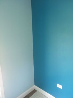 the corner of a room painted blue with white trim and carpet on the floor in front of it