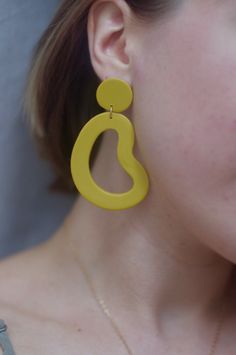 This is a pair of large statement earrings in a beautiful marigold yellow. *Please note because this color is hand mixed, slight variation occurs from batch to batch. Your particular pair of earrings may look slightly different from what is pictured, but that's because it's a unique handmade item made specially for you! These earrings are crafted using polymer clay, a surprisingly lightweight material that won't weigh you down. Each earring is carefully sanded and smoothed to ensure a well-made Yellow Earrings With Ear Wire For Everyday, Yellow Teardrop Earrings For Everyday, Yellow Teardrop Everyday Earrings, Everyday Yellow Earrings With Ear Wire, Trendy Yellow Earrings, Modern Yellow Dangle Earrings, Bold Yellow Drop Earrings, Modern Yellow Teardrop Jewelry, Modern Handmade Yellow Jewelry