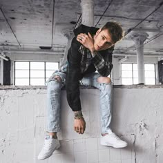 a man sitting on top of a white wall