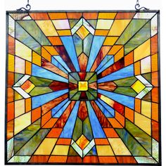 a colorful stained glass window hanging from a metal hook on a white wall with an orange and blue design in the center