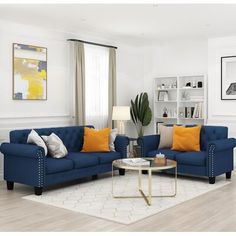 a living room with blue couches and orange pillows