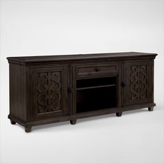 a large wooden entertainment center with an ornate design on the front and sides, in dark brown