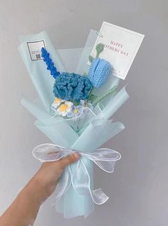 a hand holding a bouquet of blue flowers