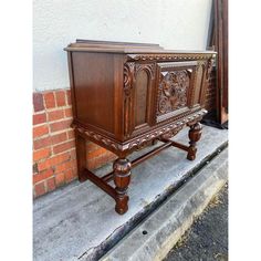 an old wooden cabinet sitting on the sidewalk