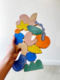 a person holding up a colorful piece of wood