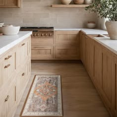 a kitchen with wooden cabinets and an area rug in front of the stove top oven