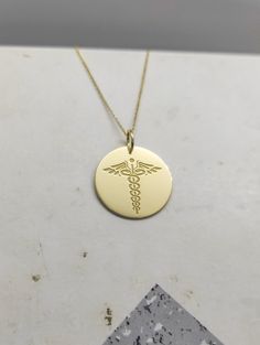 WE SHIP ALL PARCELS IN ONE BUSINESS DAY FOR FREE AND PROVIDE THE SPEEDIEST DELIVERY! Engraved Nurse Design Necklace - Medical Pendant Necklace - Handmade Nurse Gold Jewelry - Engraved Nurse Gold Necklace Engraved Nurse Pendant Necklace made out of 14K Solid Gold. Available only in Yellow Gold finish. An elegant piece of jewelry that is a perfect gift to yourself and your loved ones. Charm Thickness: 0.5mm Jump Ring inner diameter: 4mm Add your engraved personalization at the back of the pendant. Customizable Yellow Gold Anniversary Necklace, Customizable 14k Gold Pendant Necklace, 14k Gold Custom Necklace For Personalized Gift, Customizable 14k Yellow Gold Necklaces, Custom 14k Gold Necklace For Personalized Gift, Personalized Yellow Gold Jewelry For Commemoration, Customizable Yellow Gold Round Pendant Jewelry, Customizable 14k Yellow Gold Necklace, Custom 14k Gold Necklace