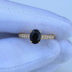 a black diamond ring sitting on top of a white cloth