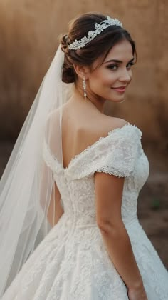 a woman in a wedding dress with a veil on her head and wearing a tiara