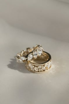 two gold wedding rings sitting on top of each other