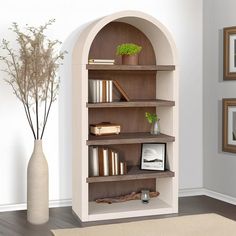 a white vase and some books on a shelf