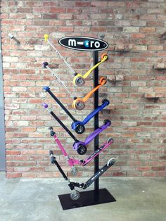 a display case with many different types of skateboards on it's sides and wheels in front of a brick wall