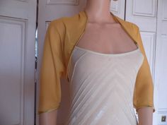 This is a beautiful hand made gold chiffon shrug ideal for weddings or special occasions. It can also be worn with casual wear. It can be made in any size from 8 to 24 (UK sizes). It is made in the UK. It is normally sent out to you within 5 days, but I am very happy to make your order a priority if you need it urgently. Just let me know the date needed by. Postage is free in the UK! International postage is £9. I am happy to exchange items or refund your payment if you are less than happy with Elegant Fitted Summer Shrug, Elegant Stretch Shrug For Spring, Spring Formal Fitted Shrug, Summer Party Shrug With Stretch, Elegant Open Front Summer Shrug, Stretch Summer Party Shrug, Fitted Shrug For Summer Wedding, Fitted Summer Wedding Shrug, Summer Wedding Fitted Shrug