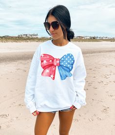 Get ready for summer and all your 4th of July activities in our cute and trendy American Bow Sweatshirt. We love this sweet sweatshirt paired with a skirt, as a beach coverup or tied over your shoulders on a cool summer evening.  A sturdy and warm sweatshirt bound to keep you warm in the colder months. A pre-shrunk, classic fit sweater that's made with air-jet spun yarn for a soft feel and reduced pilling. * 50% cotton, 50% polyester * Pre-shrunk * Classic fit * 1x1 athletic rib knit collar with Relaxed Fit Graphic Print Sweatshirt For 4th Of July, White Crew Neck Sweatshirt For 4th Of July, White Long Sleeve Tops For Independence Day, Patriotic White Cotton Sweatshirt, Casual Letter Print Sweatshirt For Independence Day, Independence Day Casual Letter Print Sweatshirt, Independence Day Letter Print Sweatshirt, 4th Of July Graphic Print Crew Neck Sweatshirt, White Long Sleeve T-shirt For Independence Day