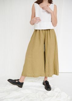 "The Clementine palazzo is the right choice for warmer days when you want to give a romantic touch to your look. The pants boast a cropped hem, in-seam pockets and a flattering gathered skirt-like high waist with an elastic band in the back. IMPORTANT: The Clementine pants have been altered to have a gathered waist instead of the pleated one. If you own a pair with pleated front, note that the pants you will receive will be different. This garment is true to size, and we recommend choosing the s Wide Linen Pants, Linen Culottes, Wide Legged Pants, Pants Linen, Pantalon Large, Gathered Skirt, Linen Trousers, Wardrobe Inspiration, Clothes Jewelry