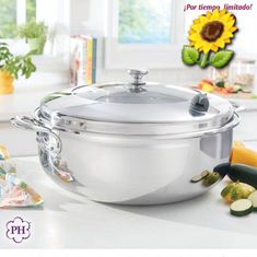 an image of a large pot with lid on the kitchen counter next to vegetables and fruit