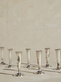 a row of silver vases sitting next to each other