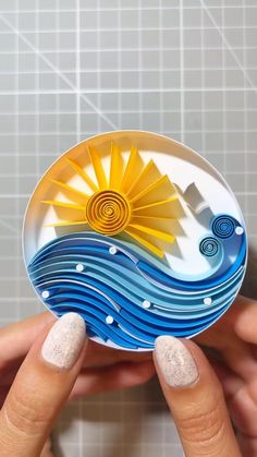 a woman's hand holding a paper plate with waves and sun on it