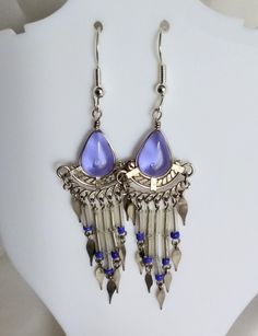 Delightful transparent purple glass earrings finished off with transparent and blue beads and white metal decorations. The teardrop shaped glass pieces measure 8x12mm.  Fitted with non-allergenic earring hooks. Bohemian Teardrop Glass Jewelry, Bohemian Teardrop Glass Earrings, Nickel-free Czech Glass Teardrop Earrings, Nickel-free Teardrop Czech Glass Earrings, Pierced Teardrop Metal Beaded Earrings, Pierced Teardrop Beaded Earrings, Purple Teardrop Metal Earrings, Purple Teardrop Metal Jewelry, Blue Metal Teardrop Chandelier Earrings