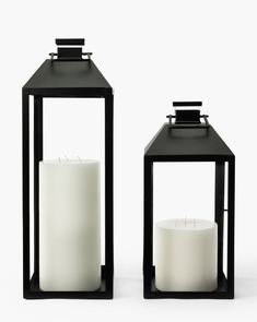 two black lanterns with white candles in them