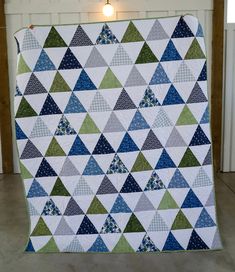 a blue and green quilt with triangles on it