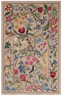 an embroidered rug with flowers and leaves on the front, in beige tones is shown