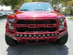 the front end of a red truck parked in a parking lot