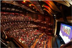 an auditorium filled with lots of people sitting in seats