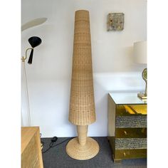 a tall wooden sculpture sitting next to a lamp