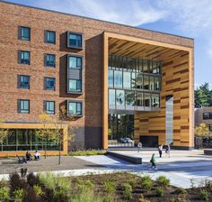 people are walking around in front of a large building with wooden panels on the side