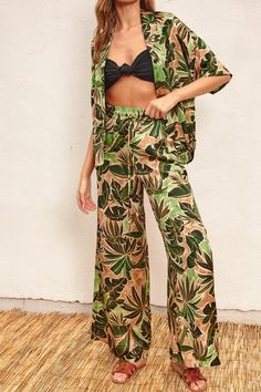 Introducing our Tropical Leaves Print Pull On Pants - the perfect combination of style and comfort. With a wide-leg design and smocked waistband featuring a drawstring, these pants will flatter any body type. The pull on design and side pockets add convenience to the chic tropical print. Unlined for a lightweight feel. Available in multiple sizes and perfect for any occasion. Fabric & fit: 100% polyester Model is wearing size Small. Tropical Leaf Print, Leaves Print, Pants Large, Leg Design, On Design, Pull On Pants, Tropical Leaves, Tropical Print, Leaf Prints