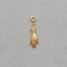 a gold charm with a hand on it