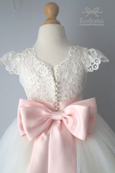 a white dress with pink bow and lace