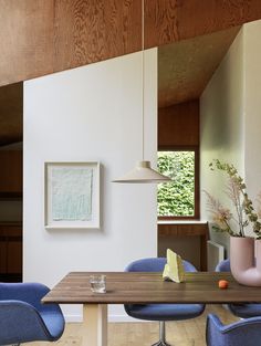 a dining room with blue chairs and a wooden table