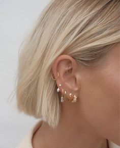 a woman with blonde hair wearing gold earrings