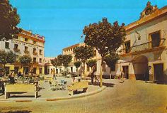 an old photo of a town square with tables and benches