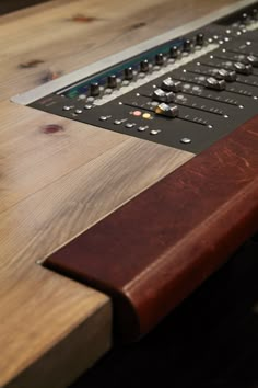 a close up of a keyboard on a wooden table with wood grained surface and metal trim