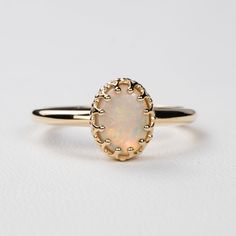 This antique style crown ring comes with a gorgeous Australian oval opal. If you want a different stone or want to add accent diamonds contact us for a quote. Details: - Default stone size is 7x5mm Australian Opal in oval shape. - Shiny finish by default. - Default width is 1.8mm at the bottom and 8.7x6.5mm at the top - Default thickness is 1.6mm at the bottom and 2mm at the top. - Contact us for quote if you want to customize this ring in any way. Thank you for shopping with Sevgi Jewelry! Elegant Opal Cabochon Ring, Classic 14k Gold Moonstone Ring Oval Cabochon, Exquisite Oval Opal Ring, Oval Opal Halo Ring In 14k Gold, Elegant Opal Ring With Center Stone, Heirloom Opal Ring Oval Cabochon, Heirloom Opal Oval Cabochon Ring, Classic Cabochon Opal Ring, Classic Opal Gemstone Ring