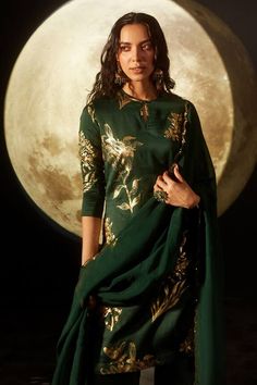 Emerald green kurta with gold floral foil print and sequin work on hem. Paired with palazzo and scallop bordered dupatta.
Component: 3
Pattern: Foil Print
Type Of Work: Floral, sequin
Neckline: Keyhole
Sleeve Type: Three quarter
Fabric: Kurta and Pant: Silk Chanderi, Dupatta: Organza, Lining: 100% Cotton
Color: Green
Other Details: 
Scallop bordered dupatta
Weight (in gms): 600
Occasion: Sangeet - Aza Fashions Chanderi Dupatta, Palazzo Set, Indian Fashion Designers, Pernia Pop Up Shop, Green Silk, Gold Floral, Foil Print, Aza Fashion, Sleeve Type