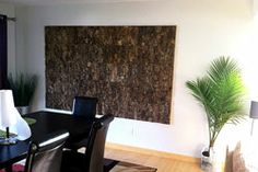 a dining room table with black chairs and a large cork board on the wall behind it