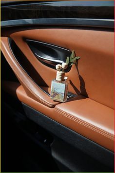 a car door handle with a small bottle on it's left side and a flower in the center