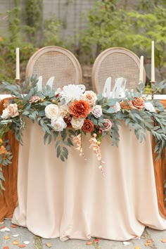 a table with flowers and candles on it is set up for an outdoor wedding reception