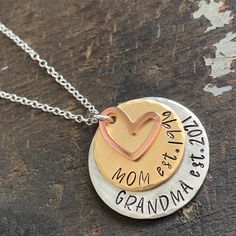 "Custom grandma necklace for a new grandma or one that's well established. Show your grandparent pride with this \"established\" mom and grandma necklace. 1\" handstamped silver alkeme tag is stamped \"Grandma est.\" with date you became (or will become) a grandma. 3/4\" solid brass disc stamped \"Mom est.\" with date you became a mom. 1/2\" copper heart charm. All pieces are hand stamped letter by letter in true artisan style. Edges are beveled and each has a brushed satin finish. Hangs from a Adjustable Necklaces For Anniversary And Mother's Day, Birthday Jewelry For Mother's Day, Round Pendant Necklace With Hallmark For Mother's Day, Custom Round Necklace For Anniversary On Mother's Day, Round Necklace With Hallmark For Mother's Day, Hand Stamped Jewelry For Birthday And Mother's Day, Hand Stamped Jewelry For Anniversary Gift On Mother's Day, Custom Round Necklace For Anniversary And Mother's Day, Hand Stamped Round Pendant Necklace As Gift For Mom